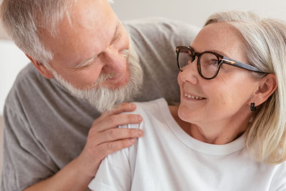 Een man slaat een arm om een lachende vrouw heen