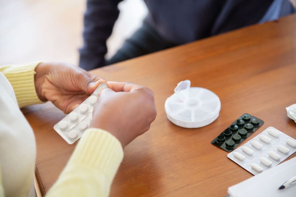Verpleegkundige legt medicatie klaar op tafel